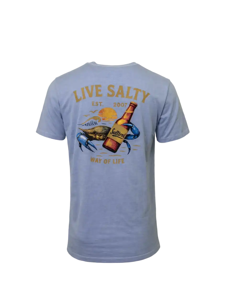 A light blue short-sleeve t-shirt shown from the back, featuring a large graphic print of a blue crab holding a brown beer bottle, with the text 'LIVE SALTY EST. 2007' and 'WAY OF LIFE'.