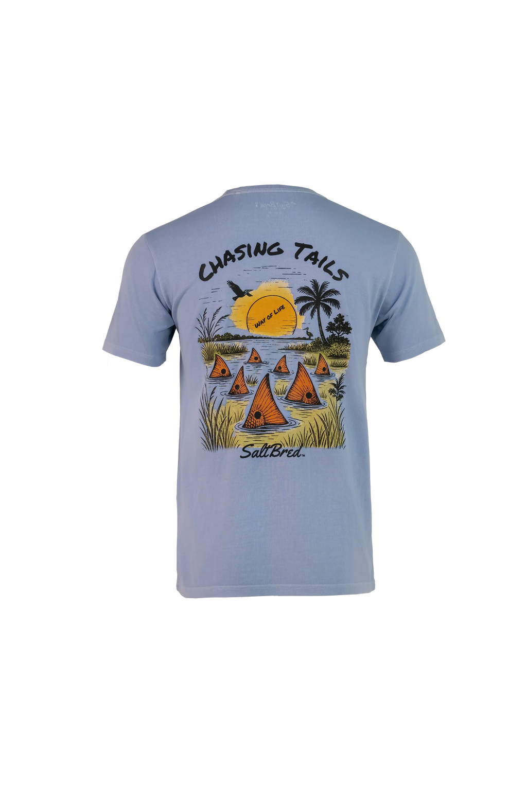 A light blue short-sleeve t-shirt shown from the back, featuring a colorful graphic print of sailboats on water with palm trees and a yellow sun, with the text 'CHASING TAILS' and 'Salt Bridge' printed on the design.