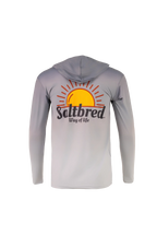 A light gray hooded long-sleeve shirt shown from the back, featuring a large graphic of a yellow and orange rising sun with the text 'Saltbred Way of life' printed across the center.