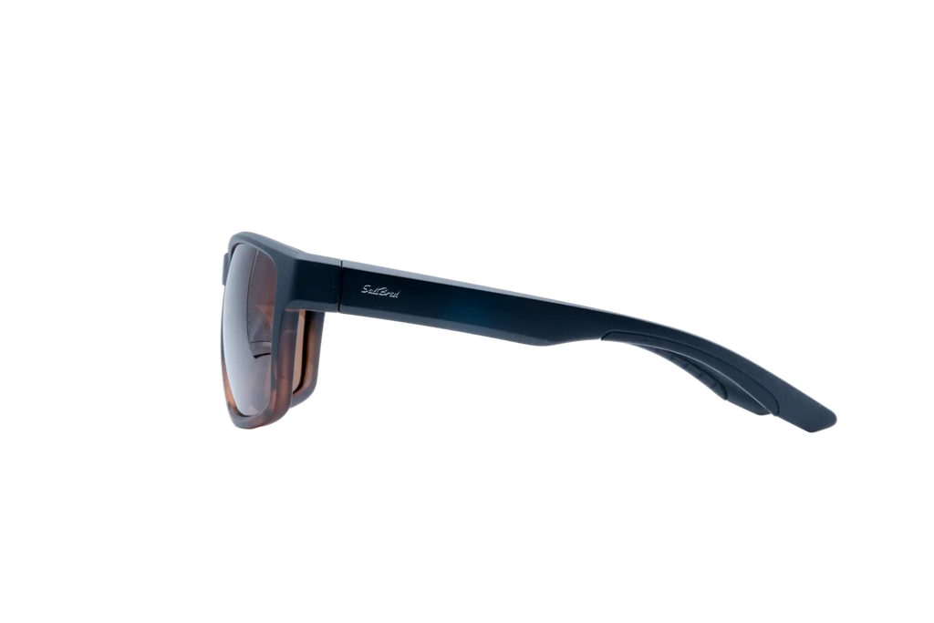 Side profile of a pair of sunglasses with a dark navy blue frame and brown-tinted lenses, shown on a solid white background.